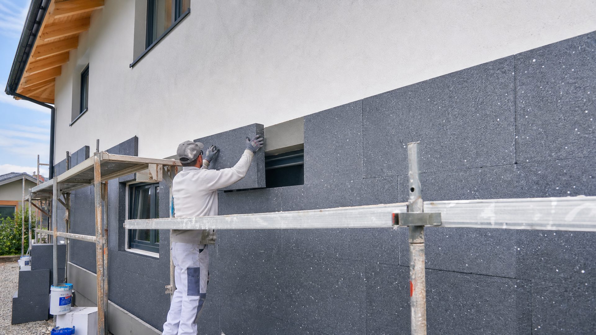Handwerker bringt eine W&auml;rmed&auml;mmung (WDVS) an einer Hausfassade an